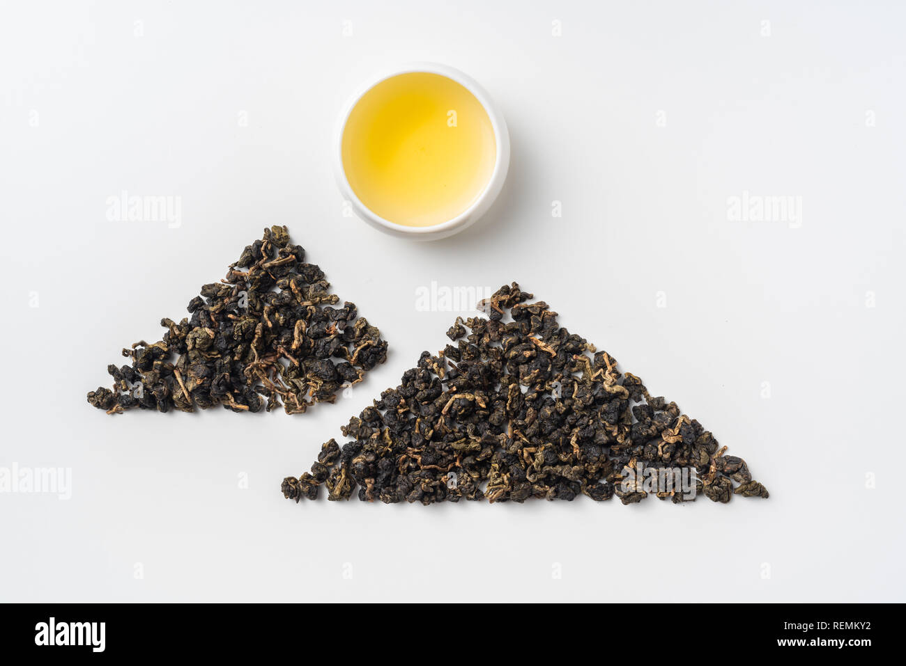 Asia culture and design concept - fresh taiwan oolong tea and cup with mountain shape made by dry tea dust Stock Photo