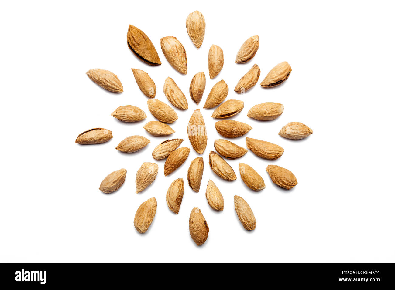 A collection of peeled almond  Badam nuts lies in the shape of a circle or sun on an isolated white background with a clipping path. Peeled Almond Bad Stock Photo