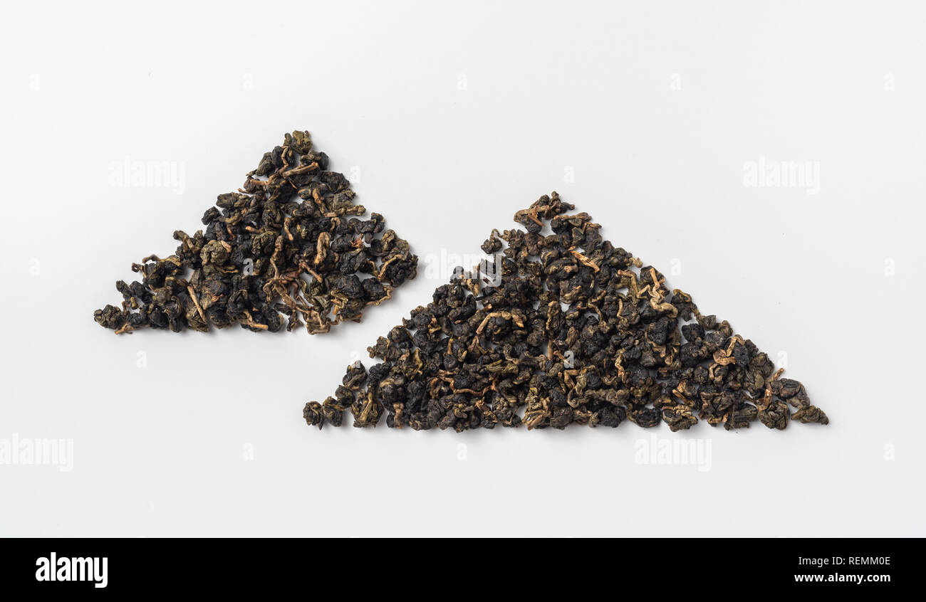Asia culture and design concept - fresh taiwan oolong tea and cup with mountain shape made by dry tea dust Stock Photo