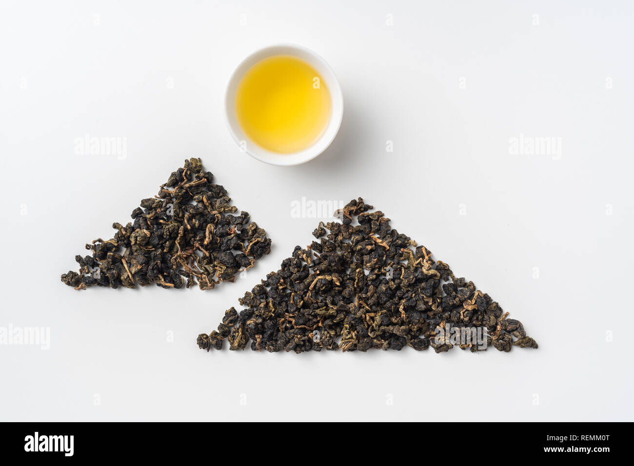 Asia culture and design concept - fresh taiwan oolong tea and cup with mountain shape made by dry tea dust Stock Photo