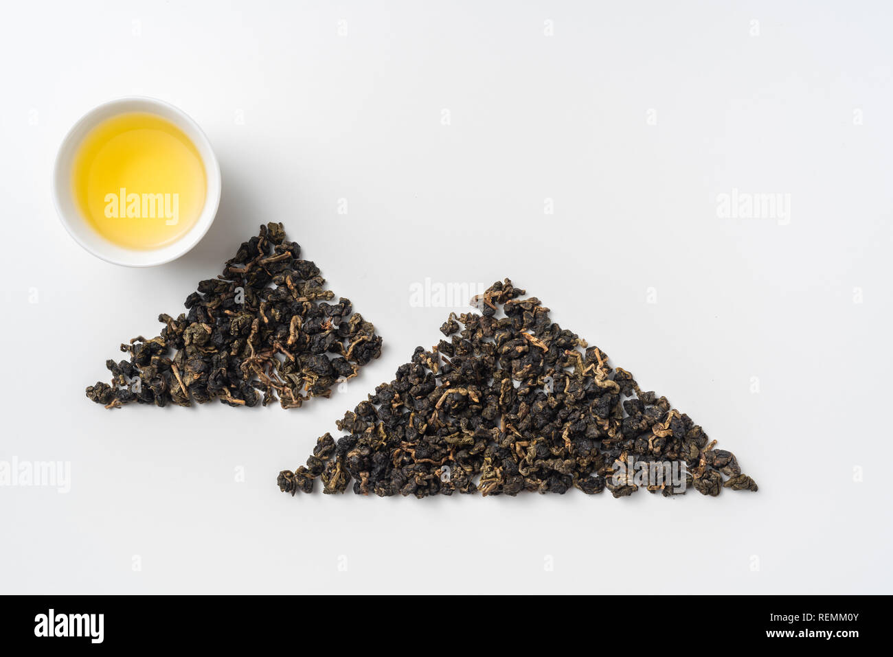 Asia culture and design concept - fresh taiwan oolong tea and cup with mountain shape made by dry tea dust Stock Photo