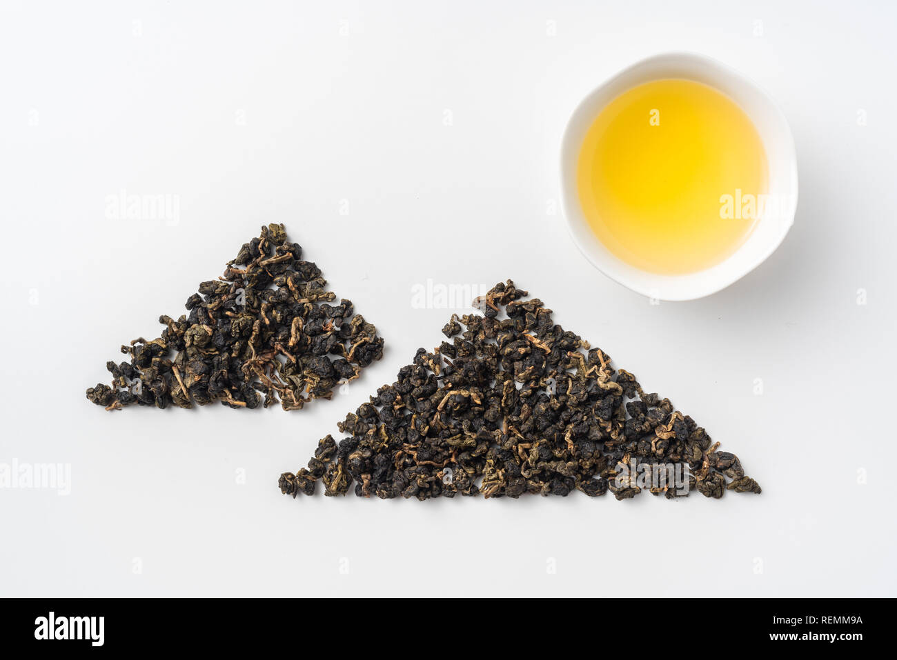 Asia culture and design concept - fresh taiwan oolong tea and cup with mountain shape made by dry tea dust Stock Photo