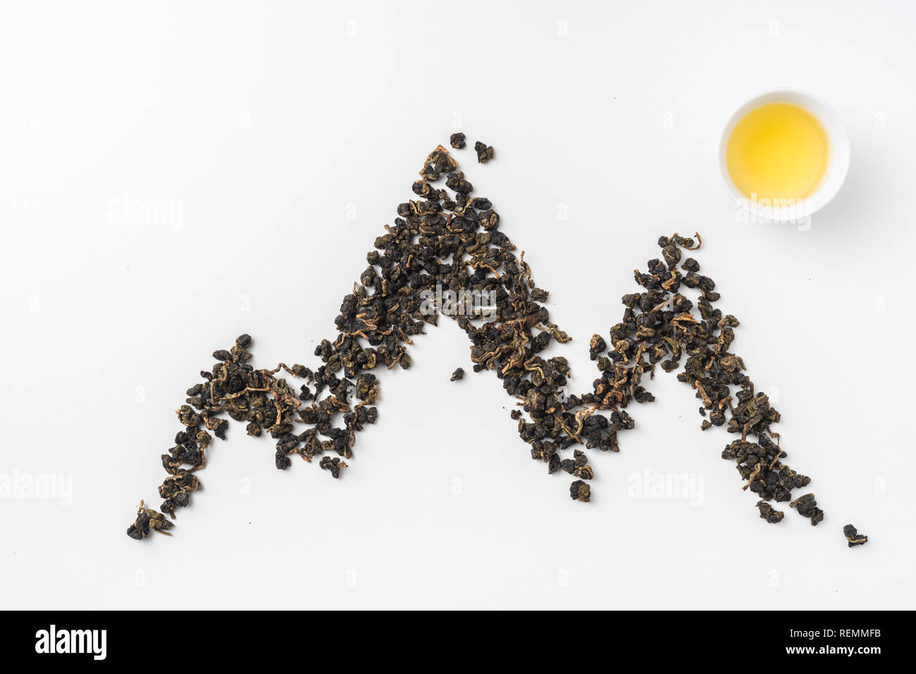 Asia culture and design concept - fresh taiwan oolong tea and cup with mountain shape made by dry tea dust Stock Photo