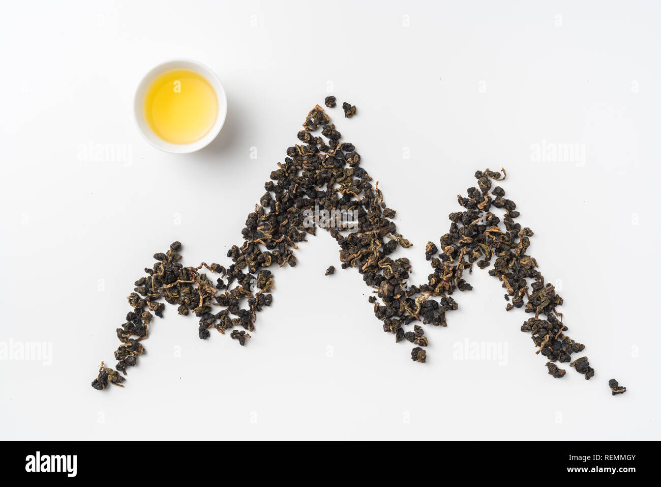 Asia culture and design concept - fresh taiwan oolong tea and cup with mountain shape made by dry tea dust Stock Photo