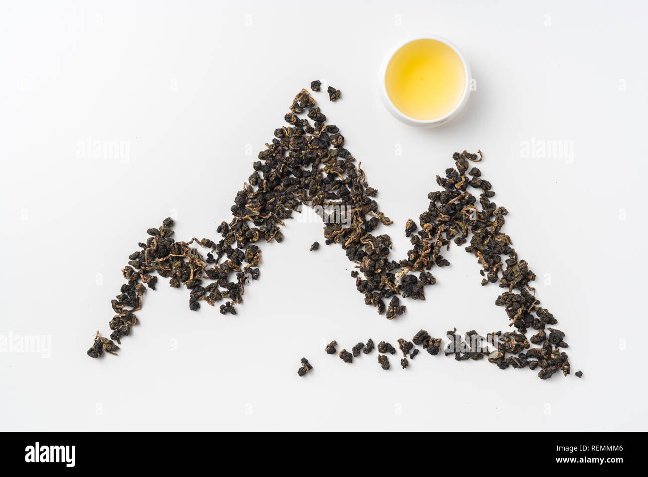Asia culture and design concept - fresh taiwan oolong tea and cup with mountain shape made by dry tea dust Stock Photo