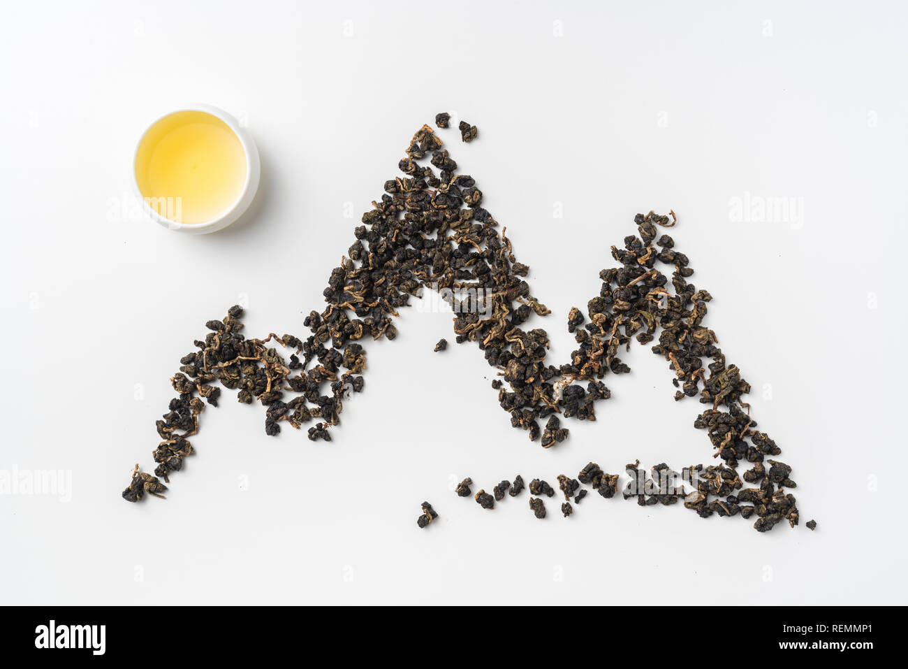 Asia culture and design concept - fresh taiwan oolong tea and cup with mountain shape made by dry tea dust Stock Photo