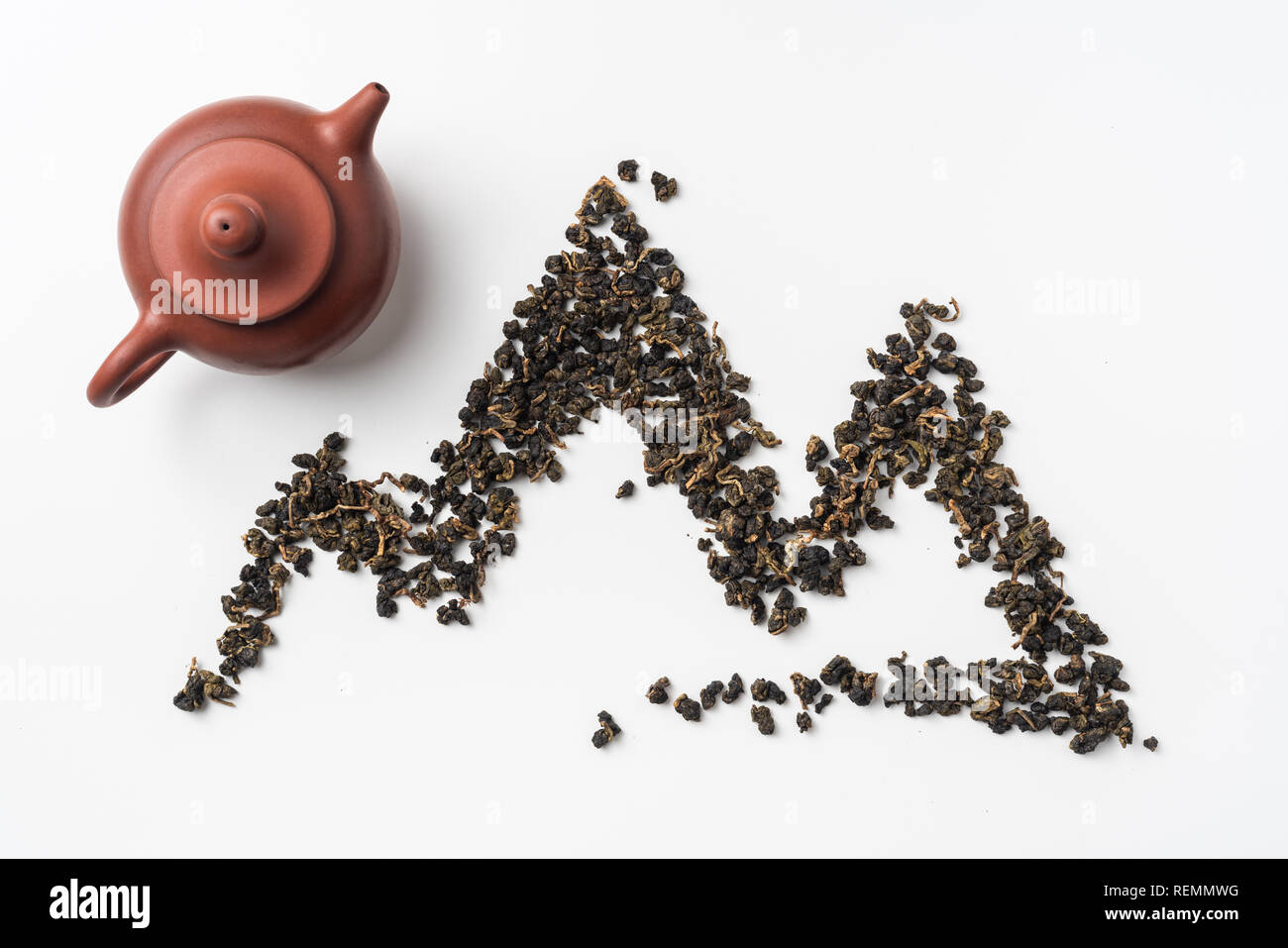 Asia culture and design concept - fresh taiwan oolong tea and cup with mountain shape made by dry tea dust Stock Photo