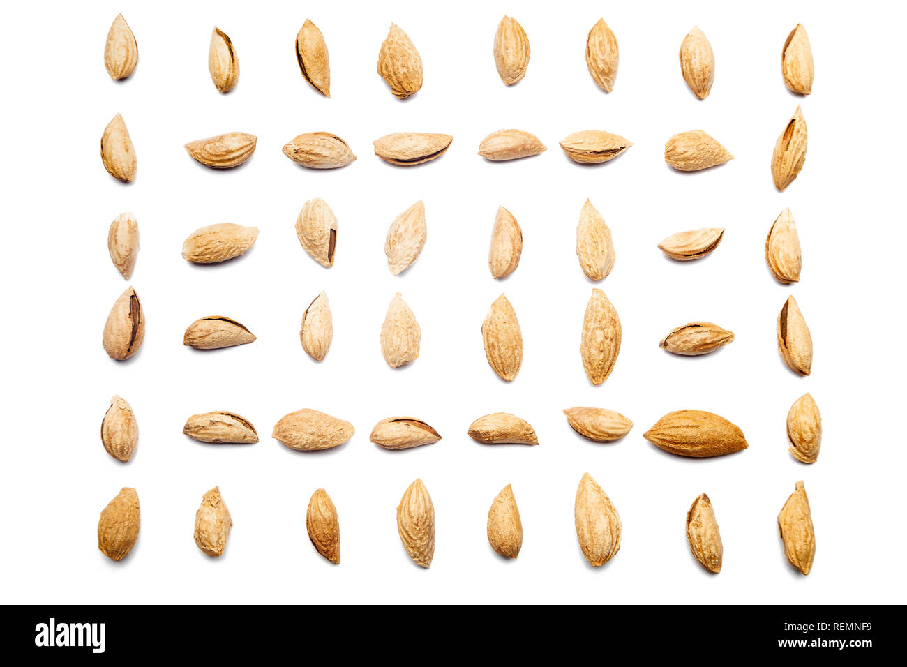 A collection of peeled almonds Badam lie in horizontal rows on an isolated white background. with clipping path. Peeled almonds Badam pattern Stock Photo