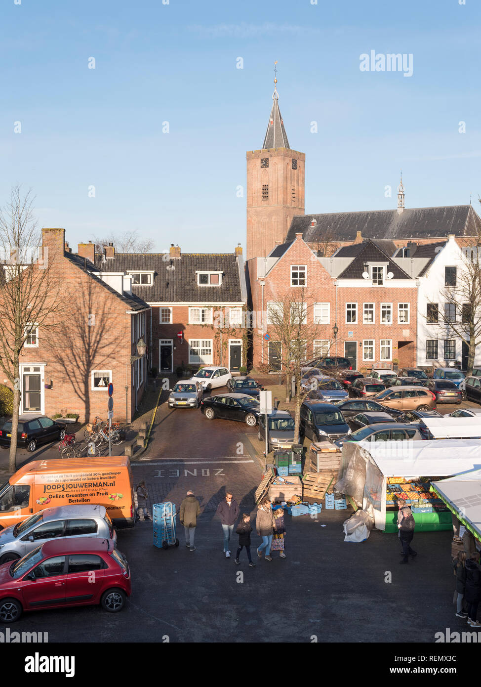 naarden, netherlands, 19 january 2019: people on open air market in the foreground of large old curch in dutch town of naarden vesting Stock Photo