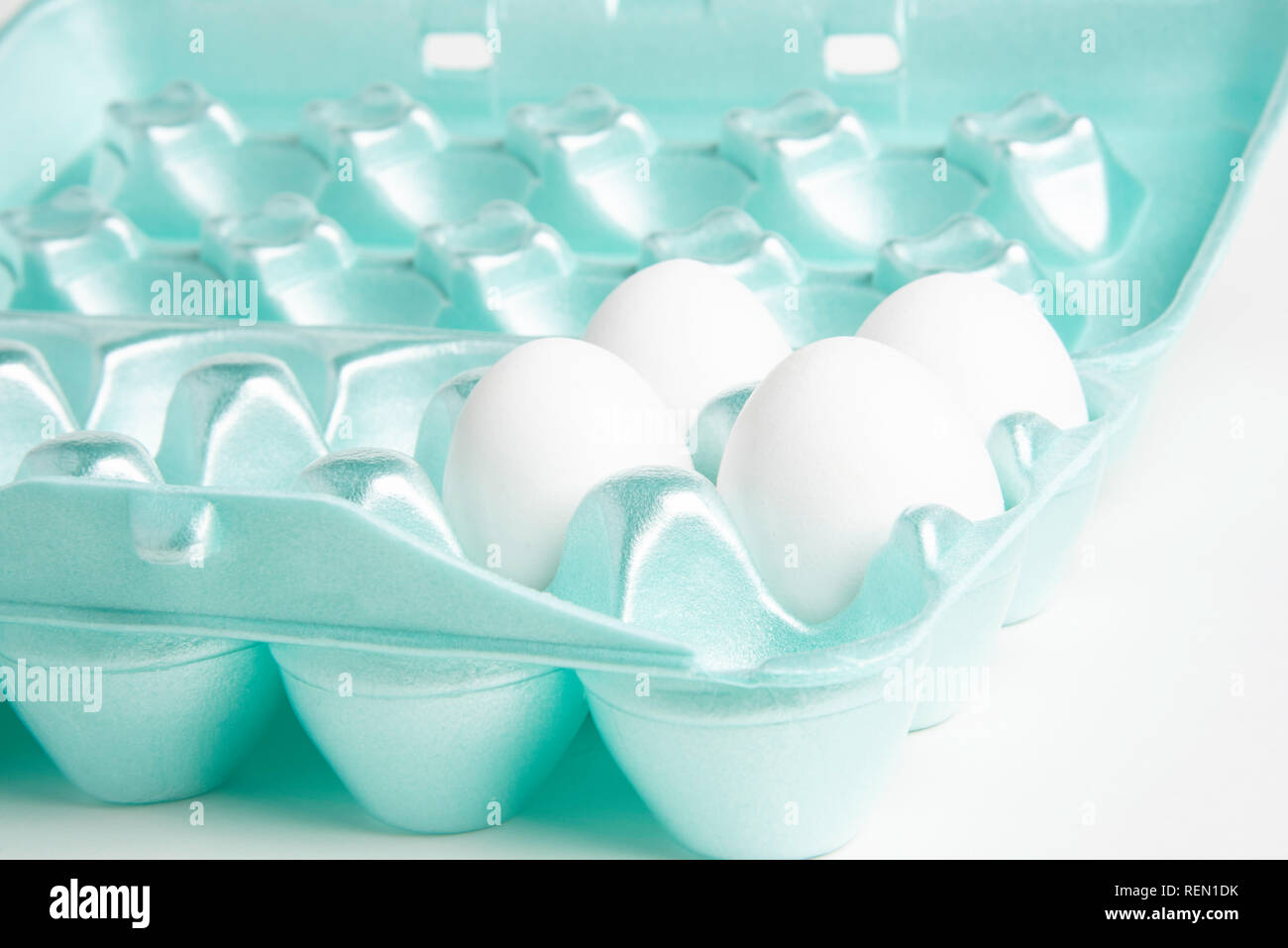 Four raw white chicken eggs in a brightlycolored 18slot eggshape