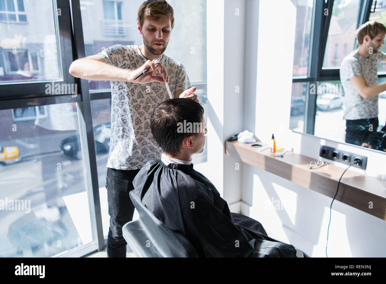 A Professional Hairstylist With A Comb And Scissors In His Hand