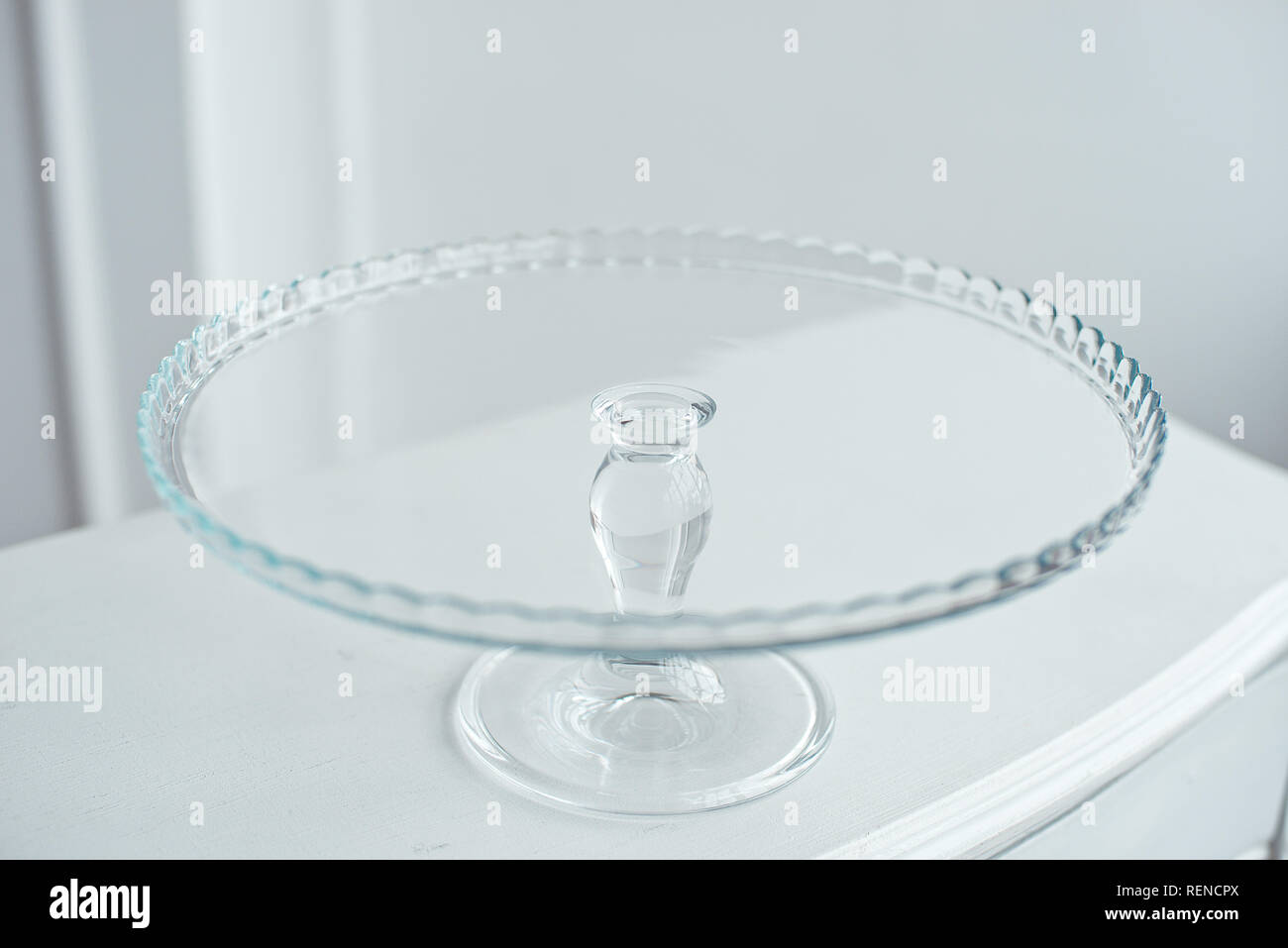 Glass cake stand on white table isolated on white background Stock Photo