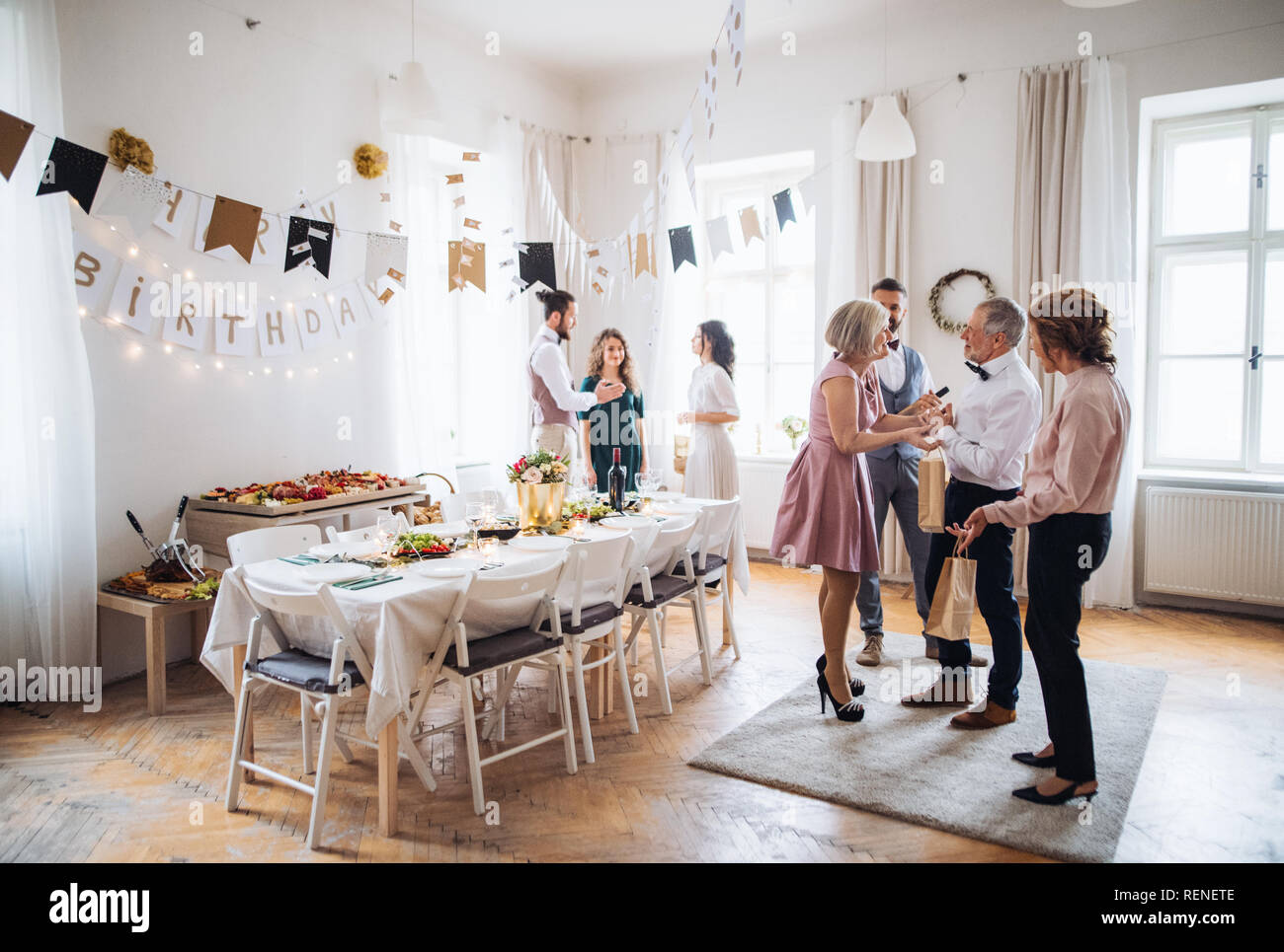 Multigeneration family with presents on a indoor birthday party. Stock Photo
