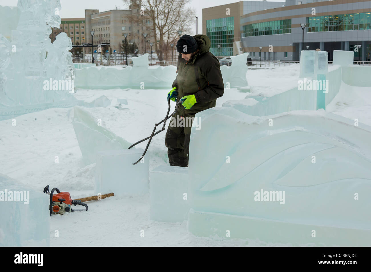 The worker pulls the ice block around the ice camp assembly site with ...