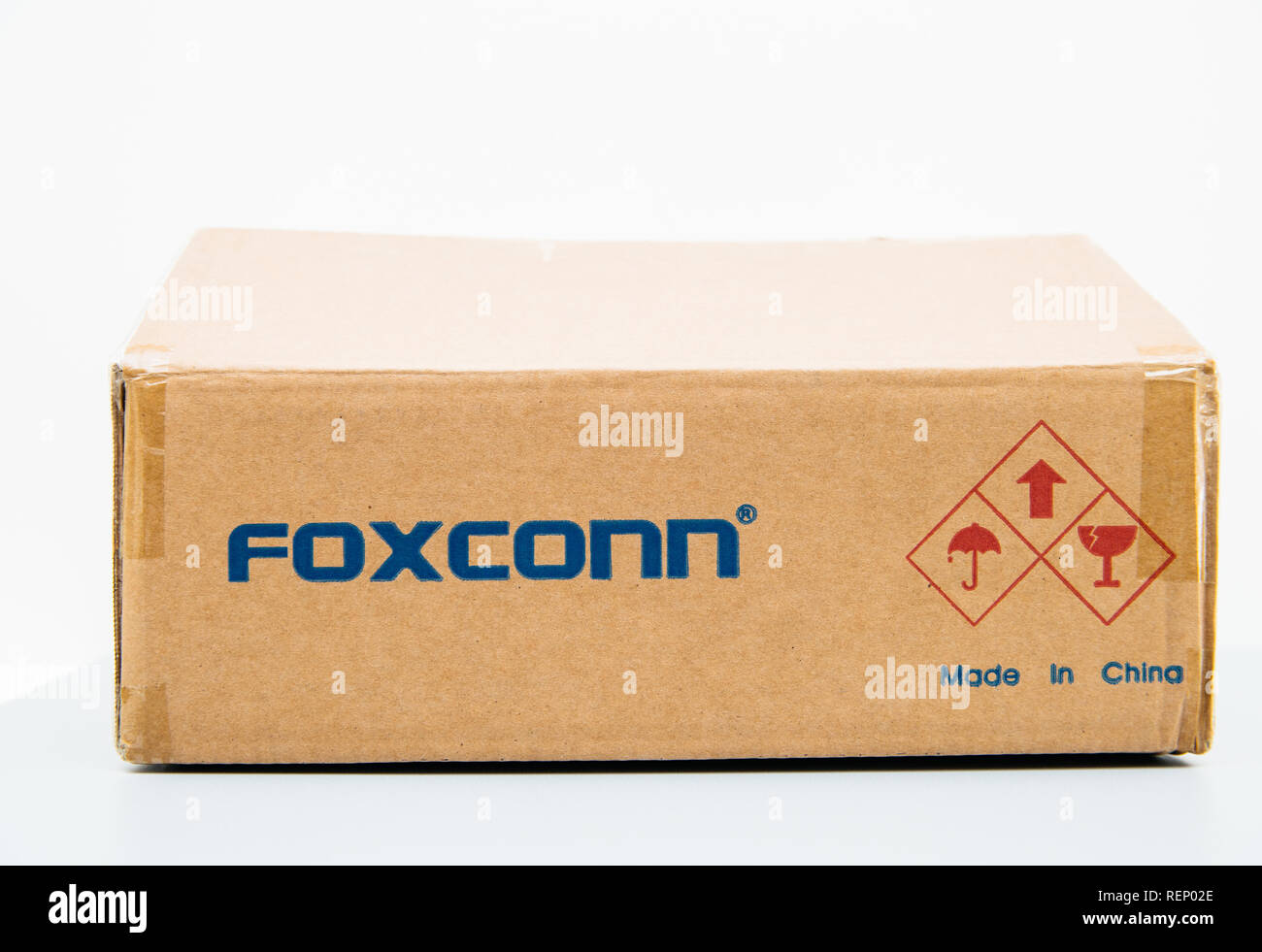 LONDON, UNITED KINGDOM - AUG 23, 2018: Unboxing Front view of Foxconn cardboard delivery box with logotype on against white background containing spare parts for computers laptop and technology part - mae in china sign Stock Photo