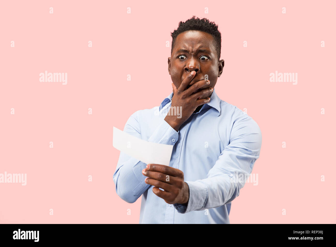 Young afro man with a surprised unhappy failure expression bet slip on ...
