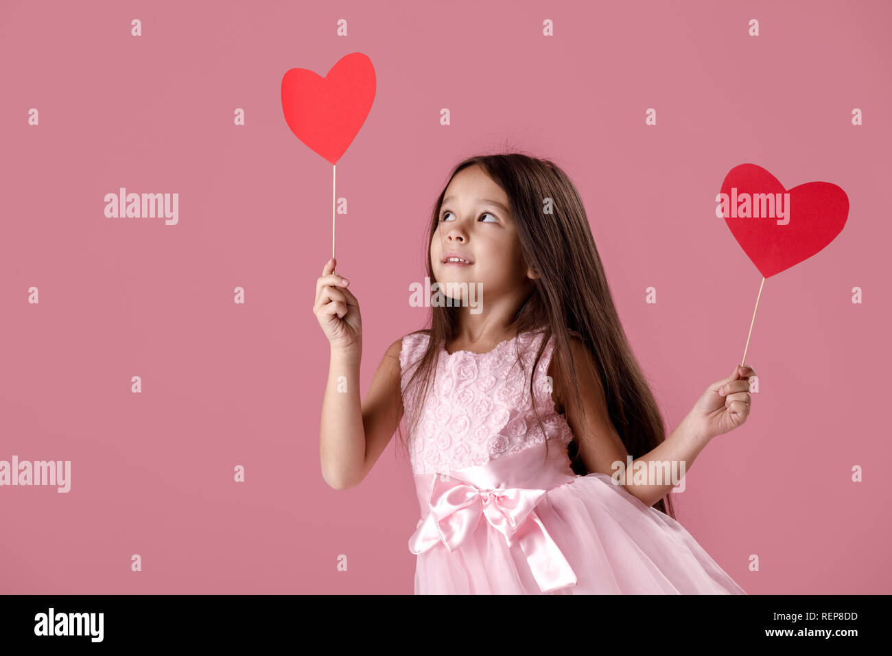 cute little girl in a pink dress holding a paper heart Stock Photo - Alamy