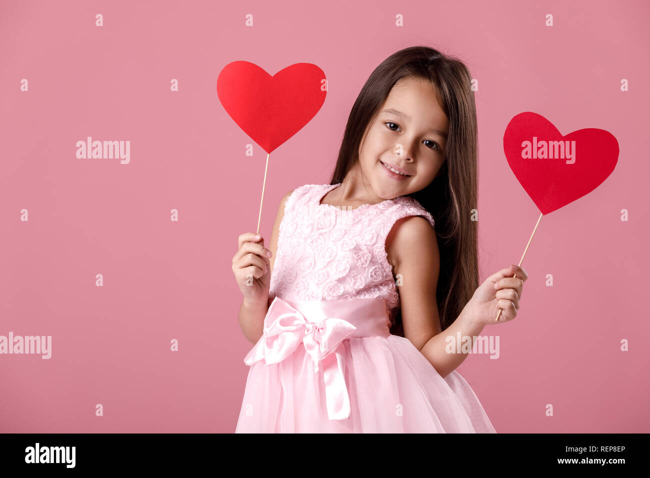 cute little girl in a pink dress holding a paper heart Stock Photo - Alamy
