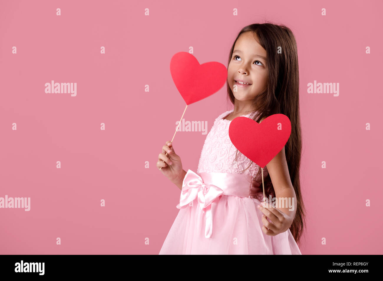 cute little girl in a pink dress holding a paper heart Stock Photo - Alamy