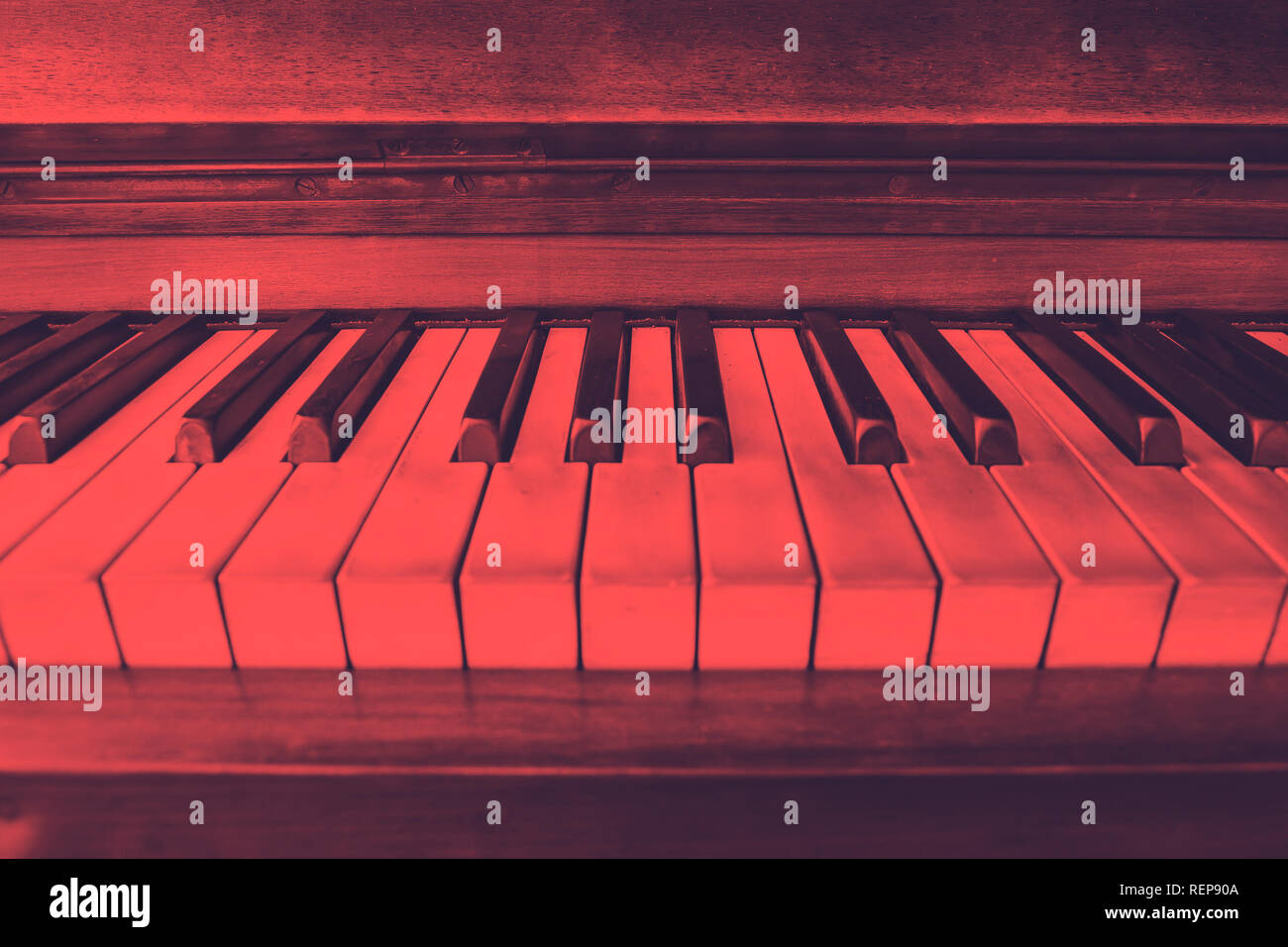 close-up view of the keys of a ancient ruined piano. Red duotone effect Stock Photo