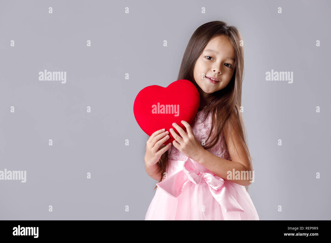 cute little girl in a pink dress holding a paper heart Stock Photo - Alamy