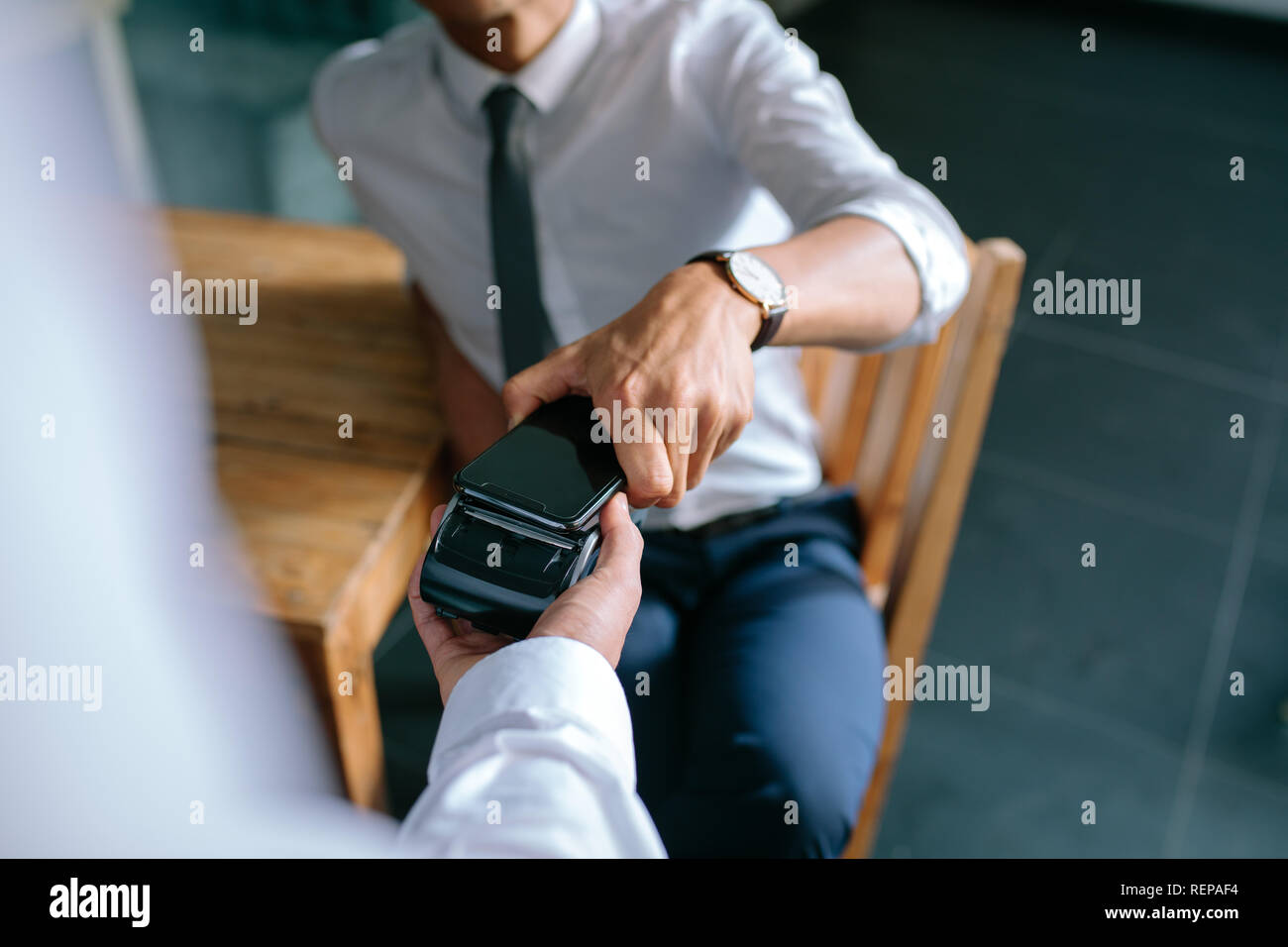 Man paying bill through mobile phone using NFC technology. Closeup of ...