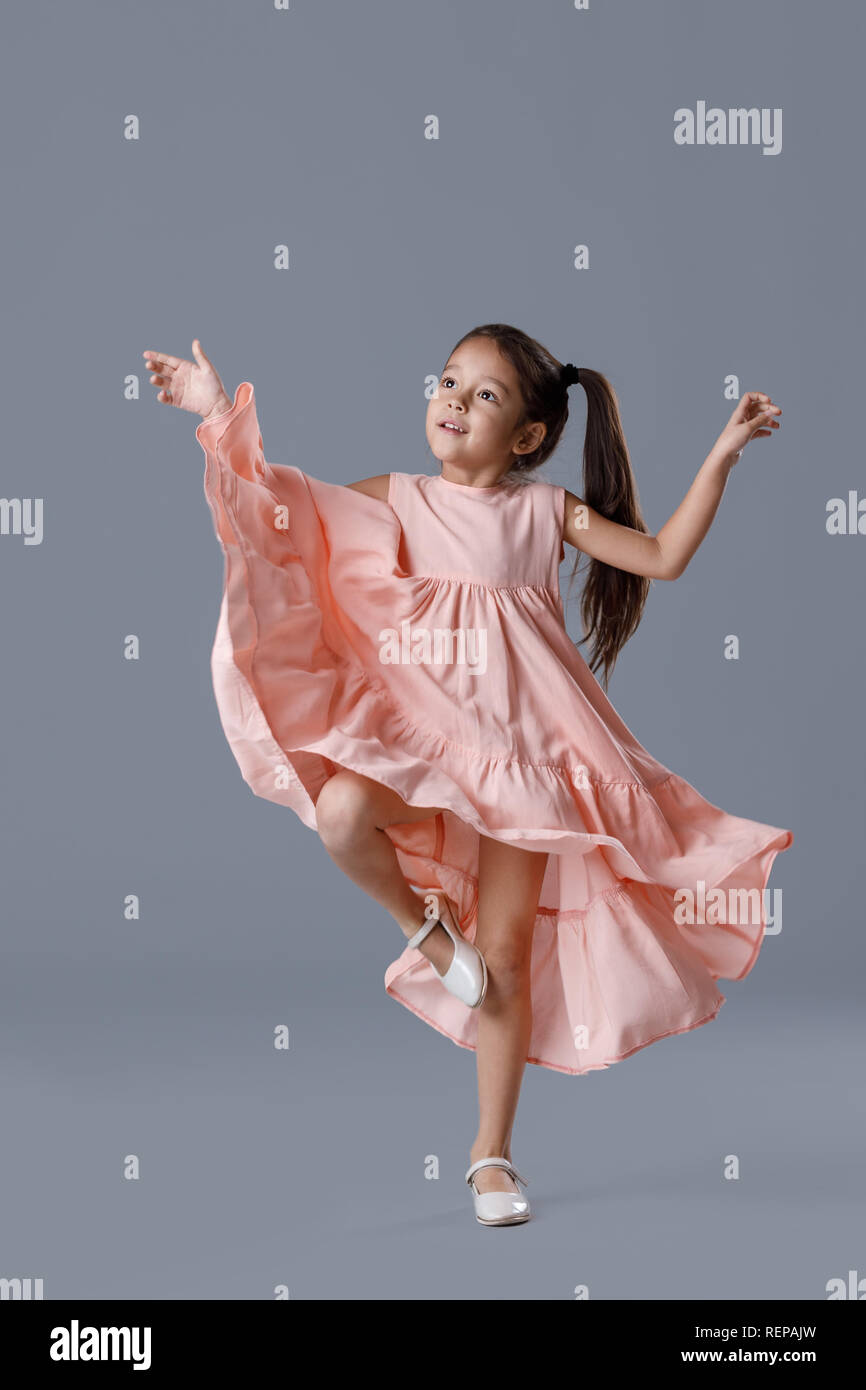 little girl in pink dress posing on gray background Stock Photo - Alamy