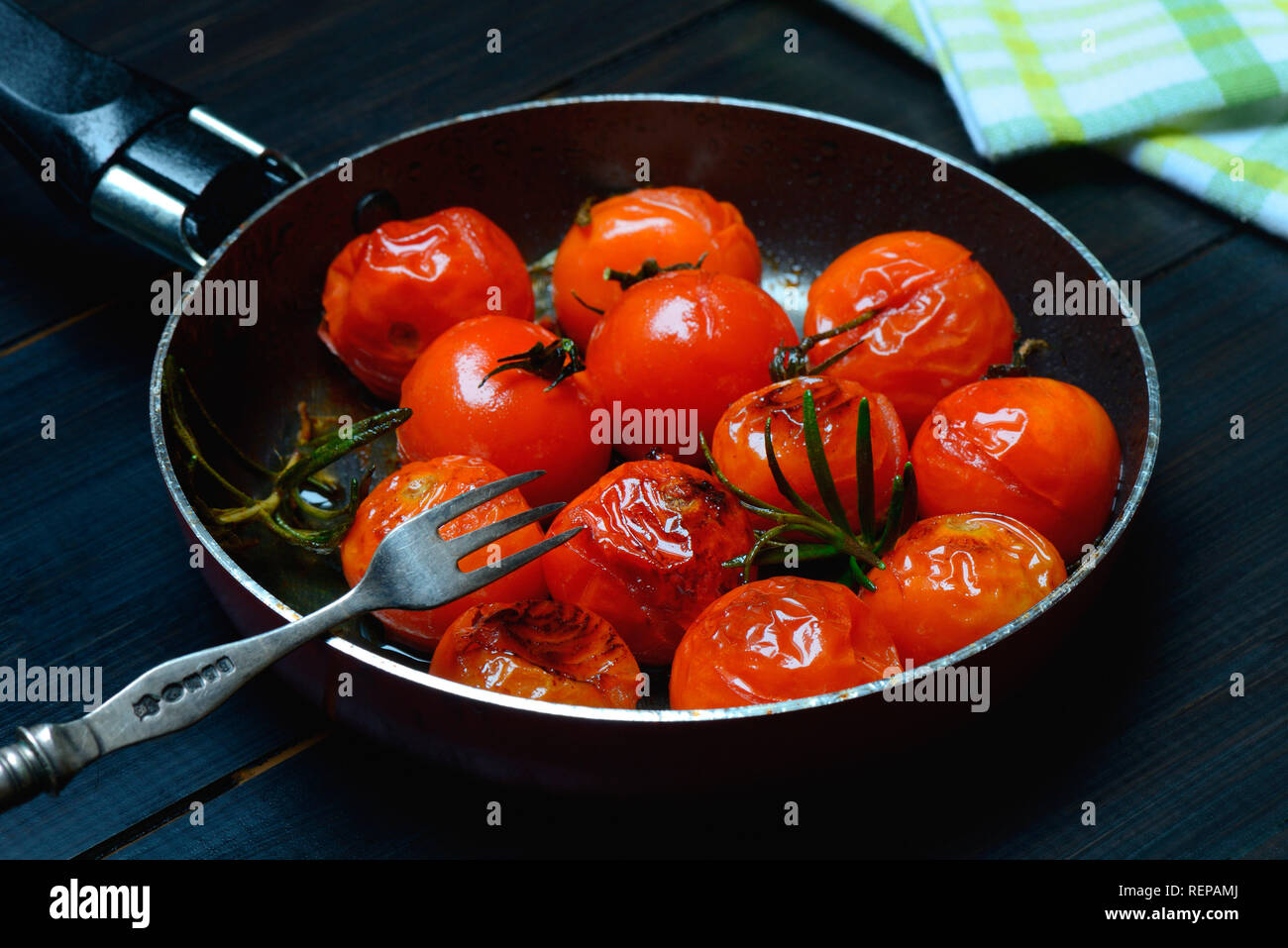 fried cherry tomatoes in pan Stock Photo