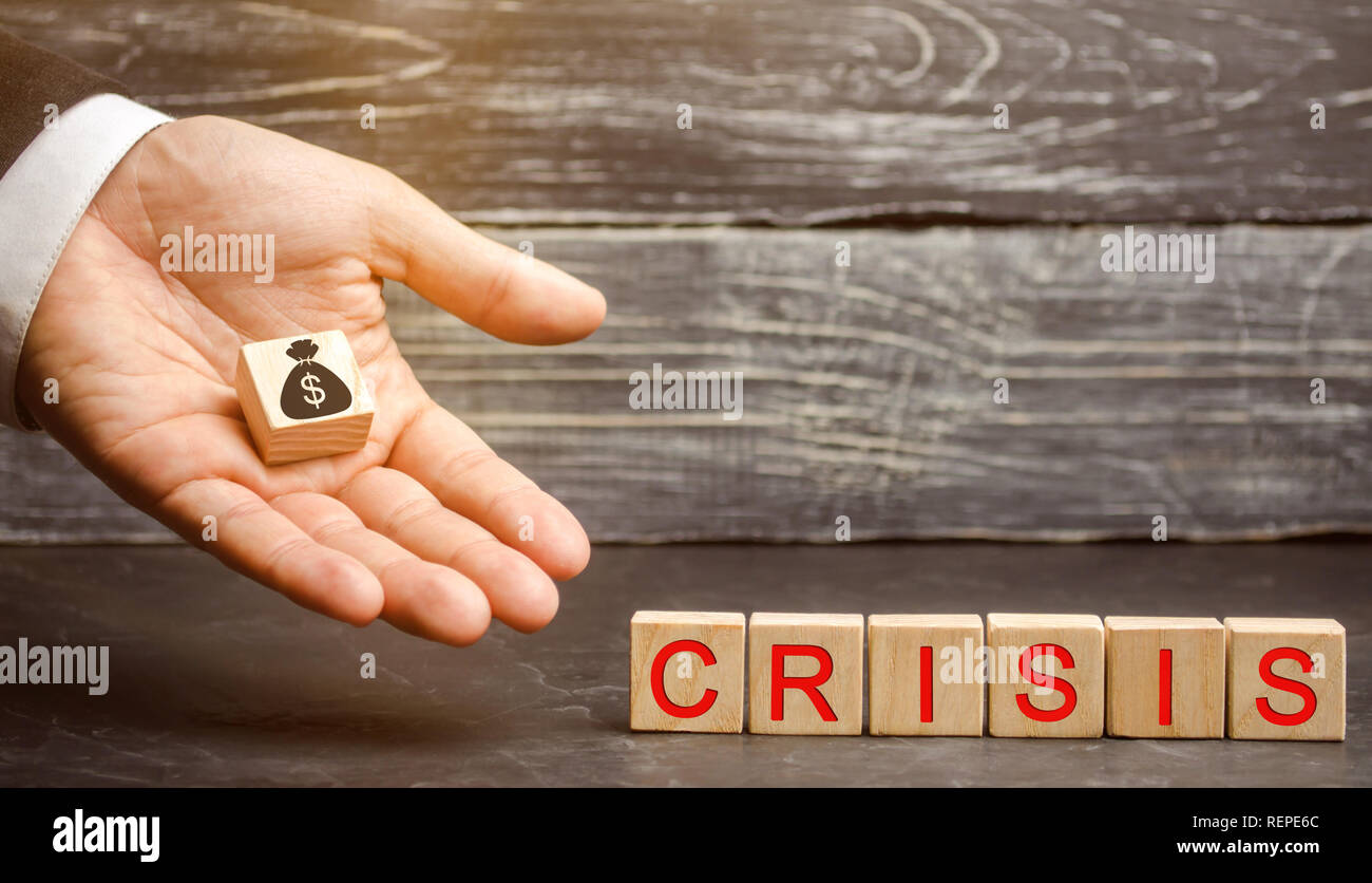 Businessman holds in his hands a cube with the image of the dollar and the word crisis. Fall business. Financial collapse. Income reduction. Bankruptc Stock Photo