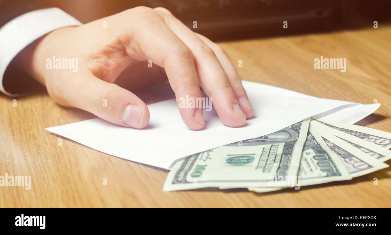 The concept of corruption and bribery, law and money. Dark business. Businessman receives money in an envelope. Bribe in the form of dollar bills. Han Stock Photo