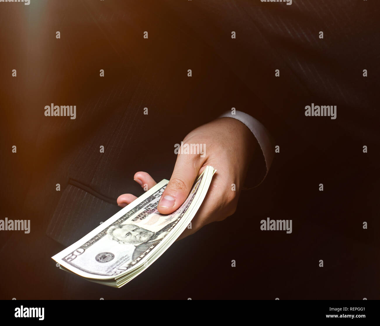 The concept of corruption and bribery, law and money. Dark business. Businessman receives money - Bribe in the form of dollar bills. Hand receiving mo Stock Photo