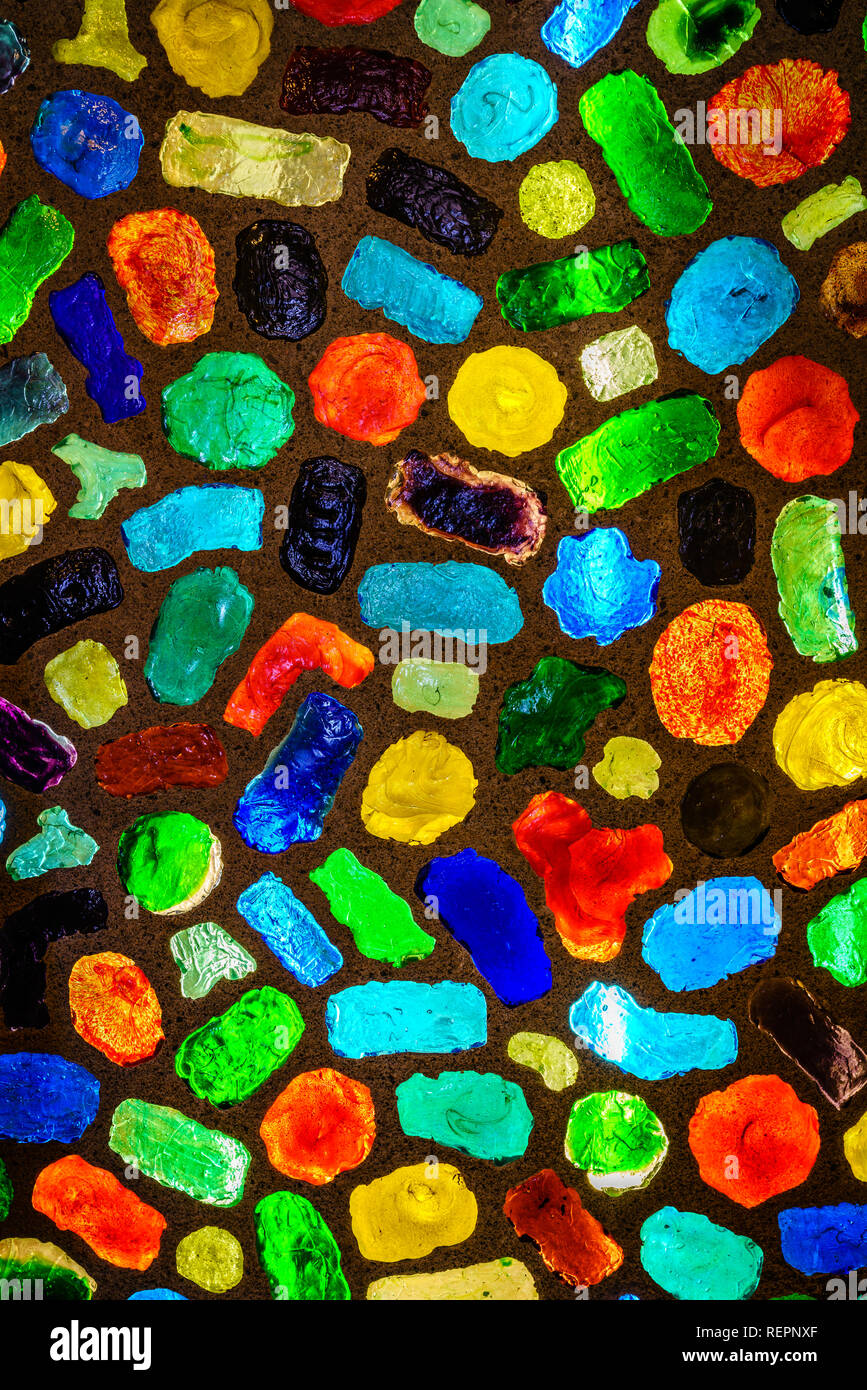 Pieces of colored glass embedded in concrete wall and back-lit Stock Photo