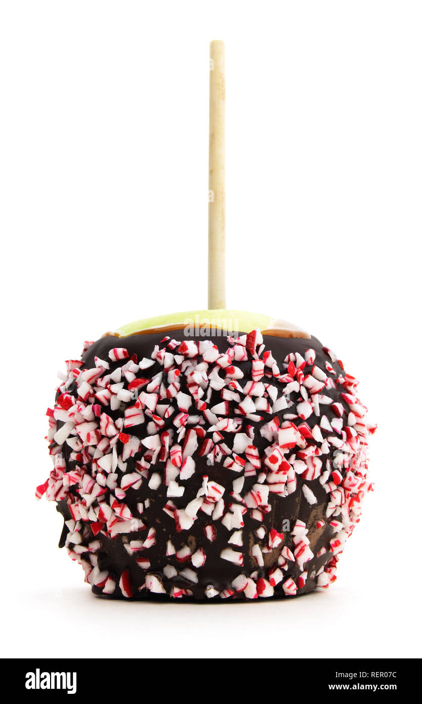 Isolated candy apple with candy cane chips. Low view of isolated candy apple drizzled with candy cane chips. Stock Photo