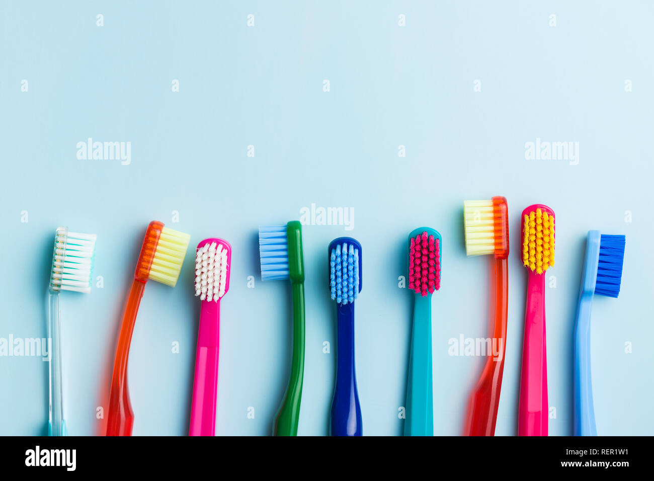 Colorful toothbrushes on blue background. Top view Stock Photo - Alamy