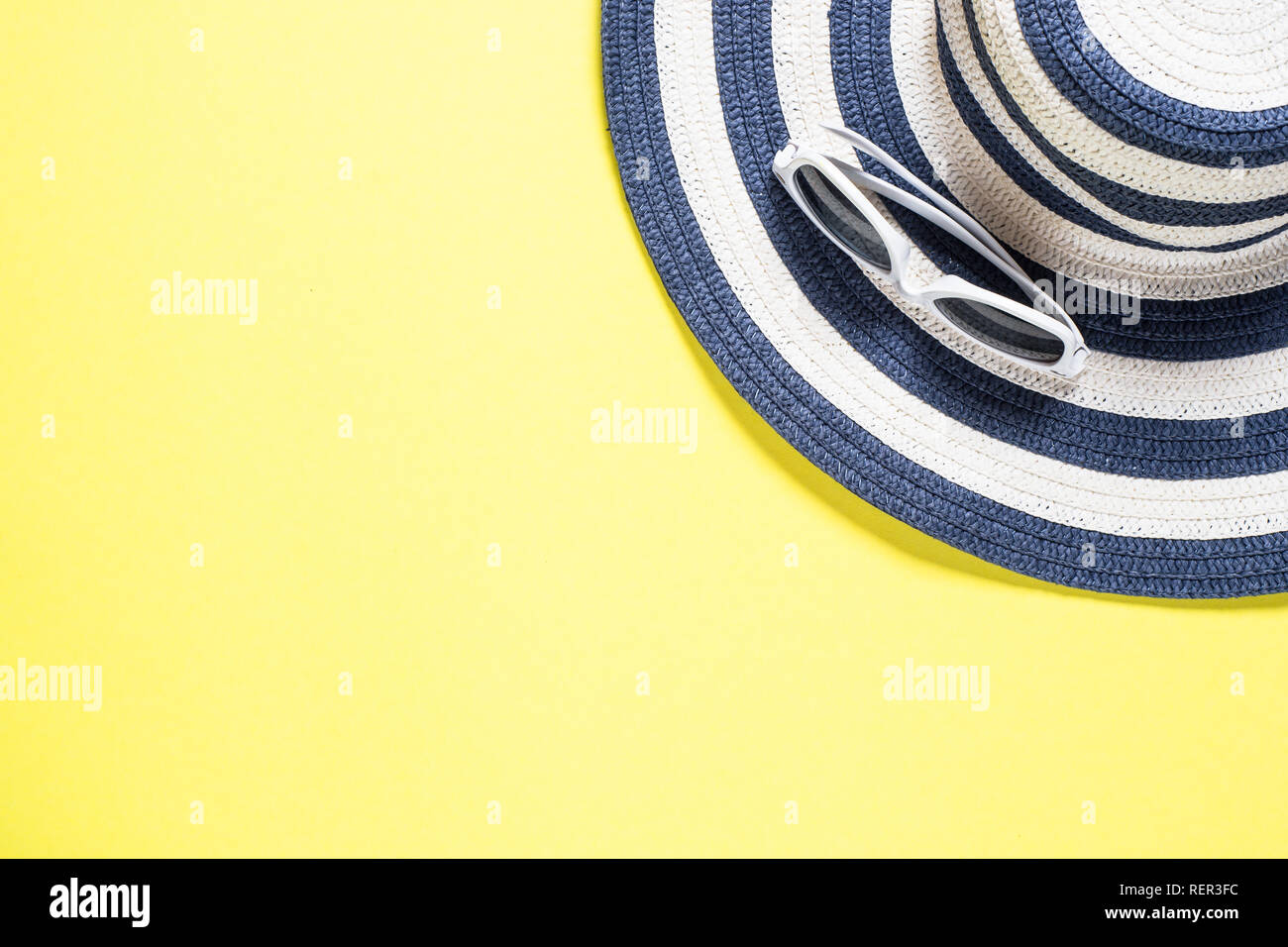 Summer travel vacation concept. Striped hat and sunglasses on yellow ...