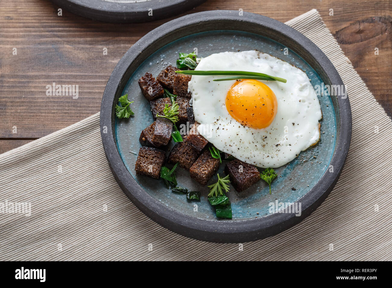 Breakfast with fried egg and croutons, close view copy space Stock Photo