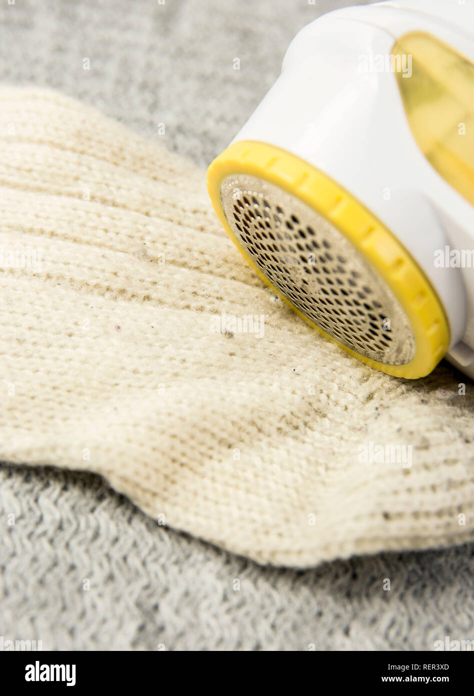 Removing sheaving lint fuzz from white woolen socks, wool clothes maintain concept. Stock Photo