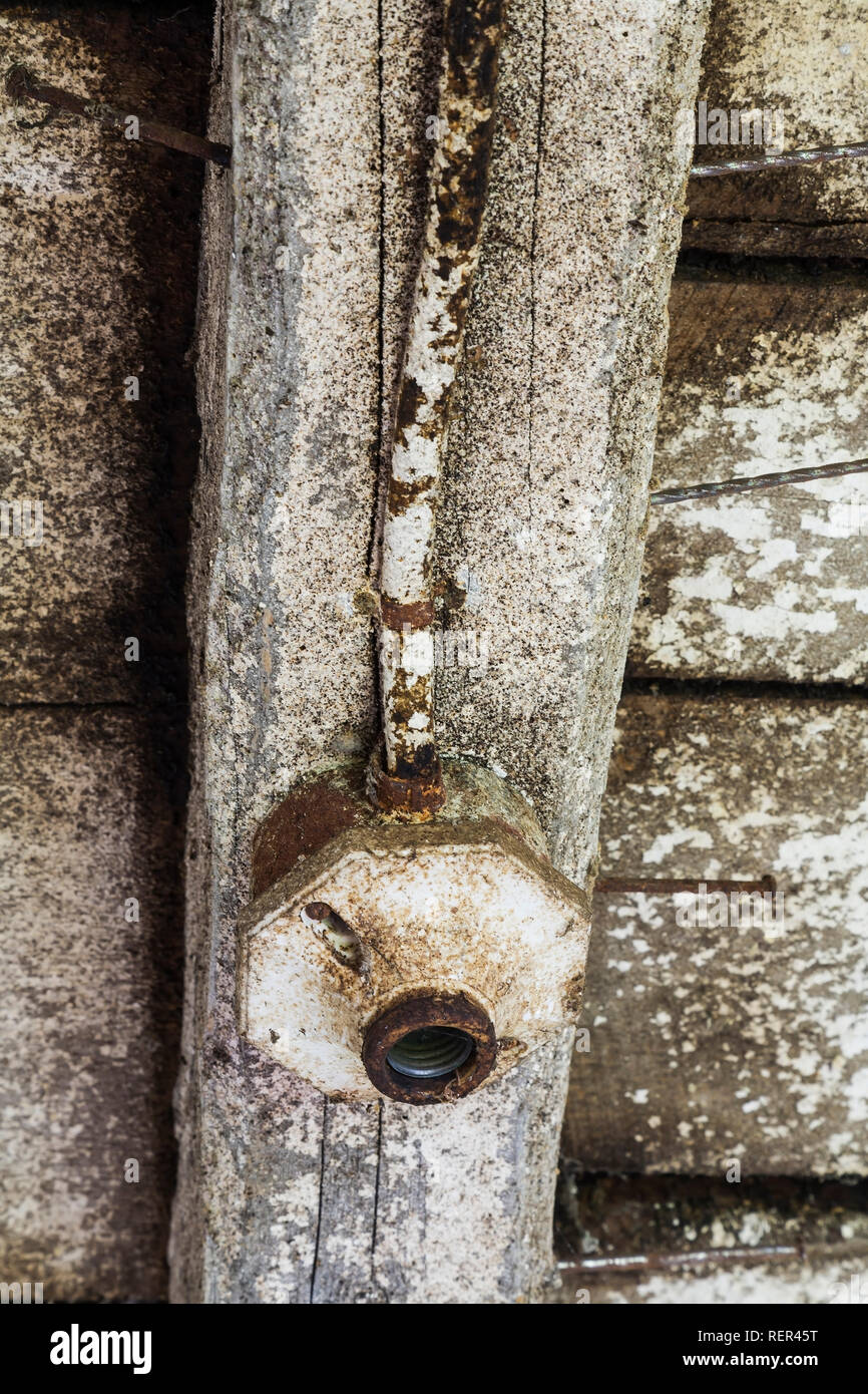 Close Up Of Empty Lighting Fixture And Faded White Painted Wood