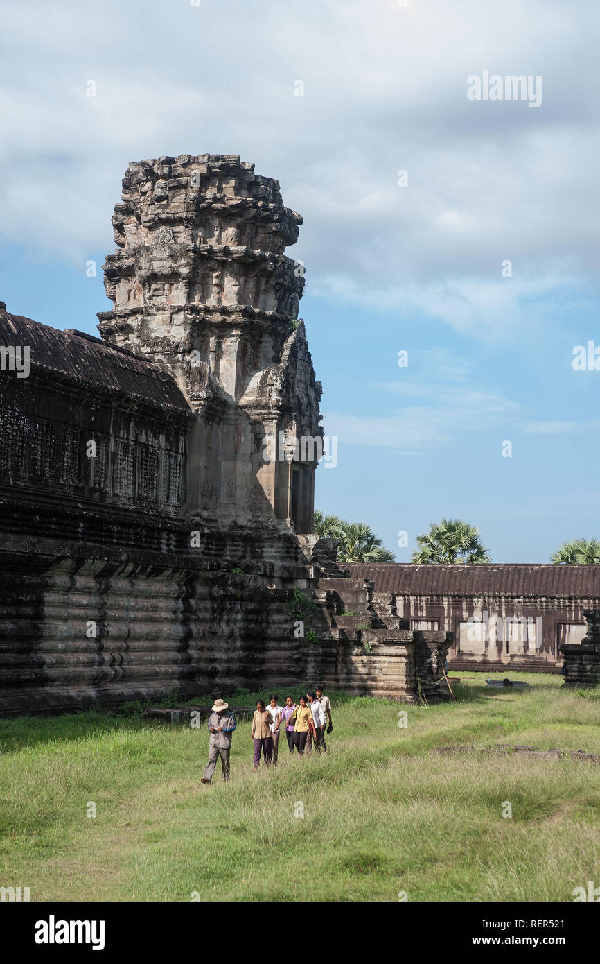 A small group of people walk through the second level enclosure, Angkor Wat, Siem Reap, Cambodia Stock Photo