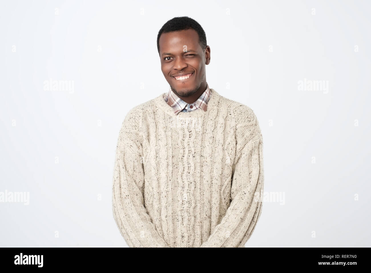 Dark skinned man blinks eye and has appealing smile, flirts with beautiful woman. Stock Photo