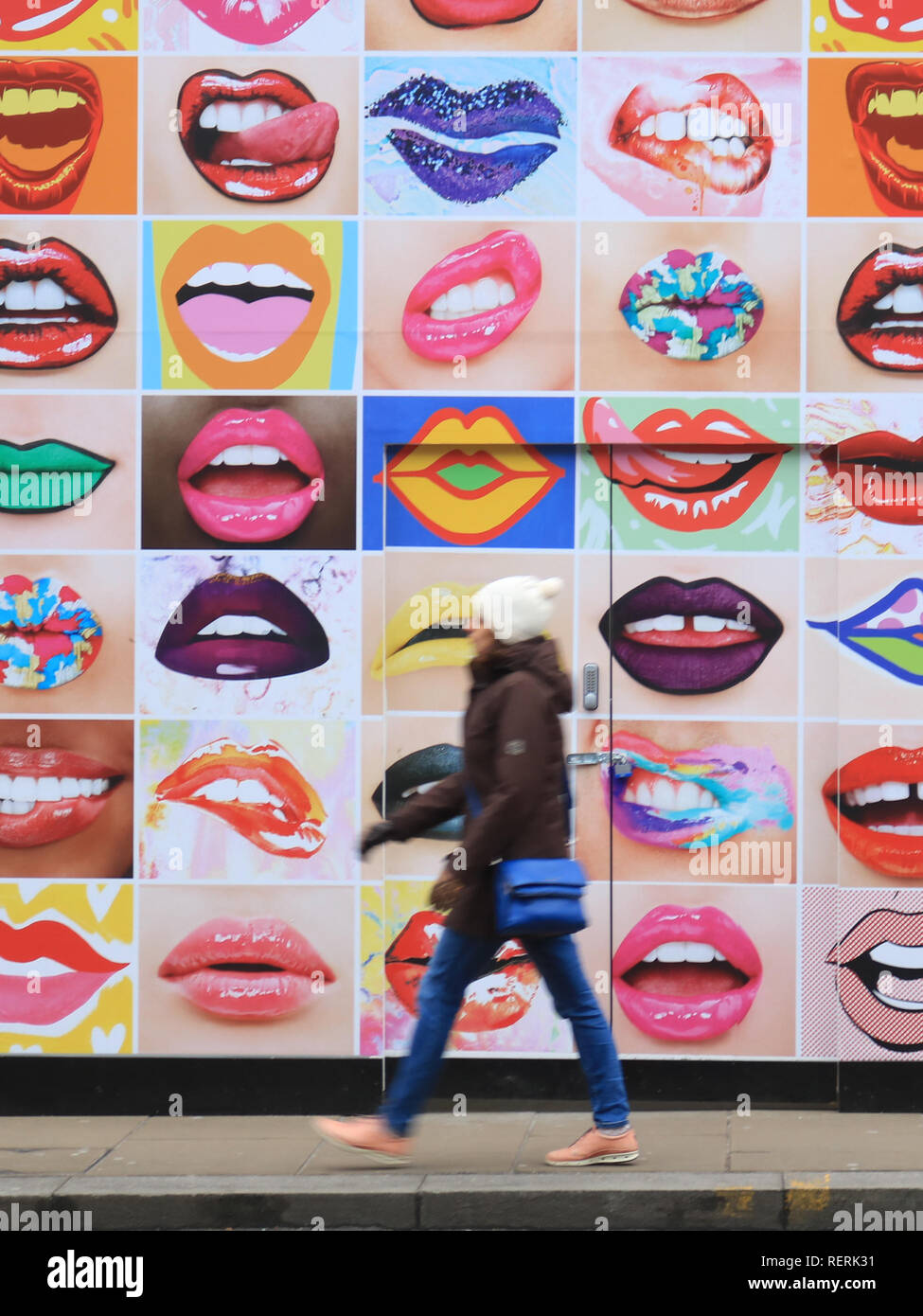 London UK. 23rd January 2019. Pedestrians walk past a mural in Wimbledon High Street with human lips on a cold winter day with temperatures forecast to stay below freezing Credit: amer ghazzal/Alamy Live News Stock Photo