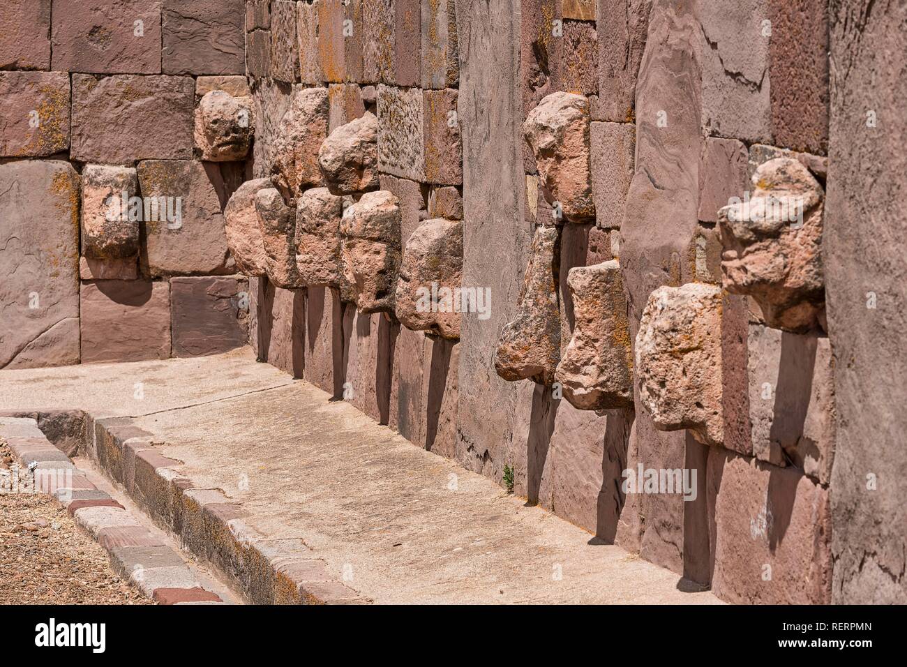 Stone heads in wall of Kalasasaya temple (place of standing stones) with monoliths from pre-Inca period Stock Photo