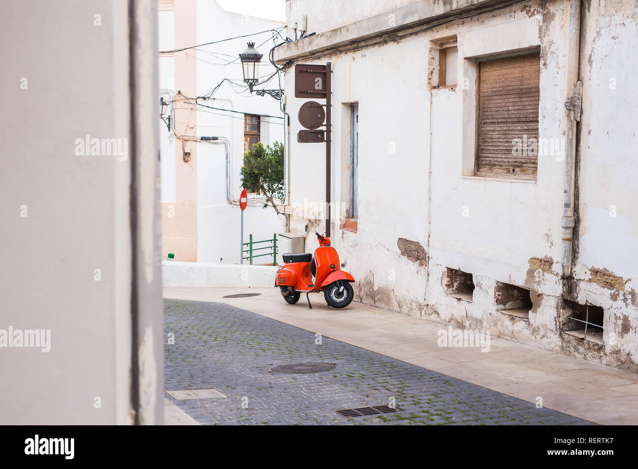 Barcelona, Spain - January 13 , 2018: Orange Scooter Vespa parked on old street in Barcelona, Spain Stock Photo