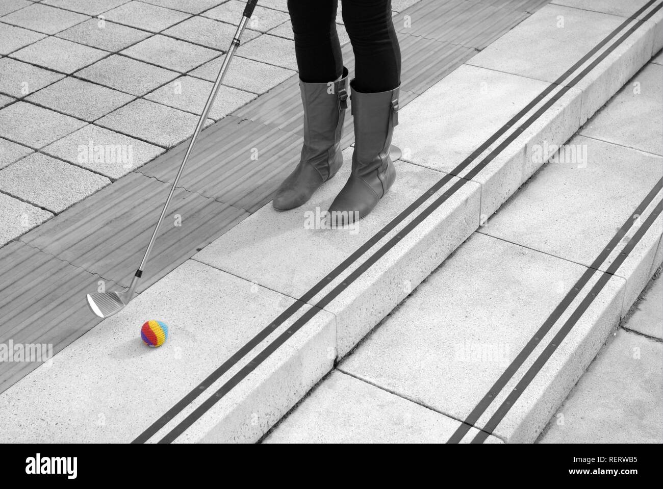 Legs of a young woman who is playing urban golf Stock Photo