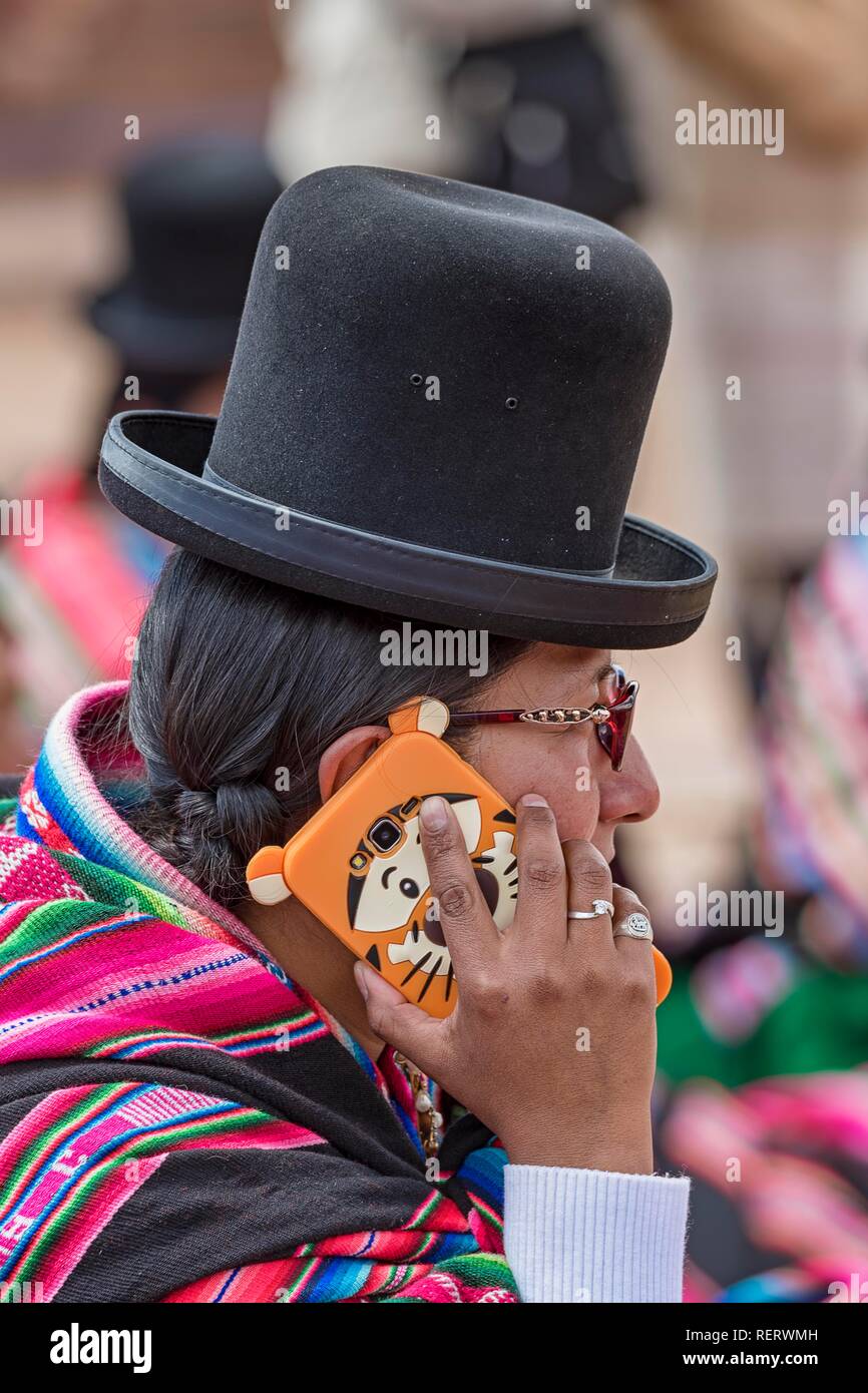 Indigenous woman (chola, cholita) in typical national clothing (pollera, overskirt and scarf, manta ray) with typical hat Stock Photo