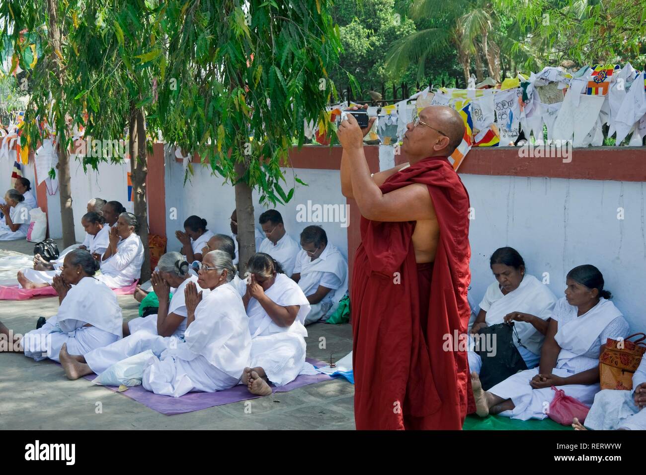 Monk filming in the Dhammachakkapavattana Sutta Memorial Park, Sarnath, Uttar Pradesh, India, South Asia Stock Photo