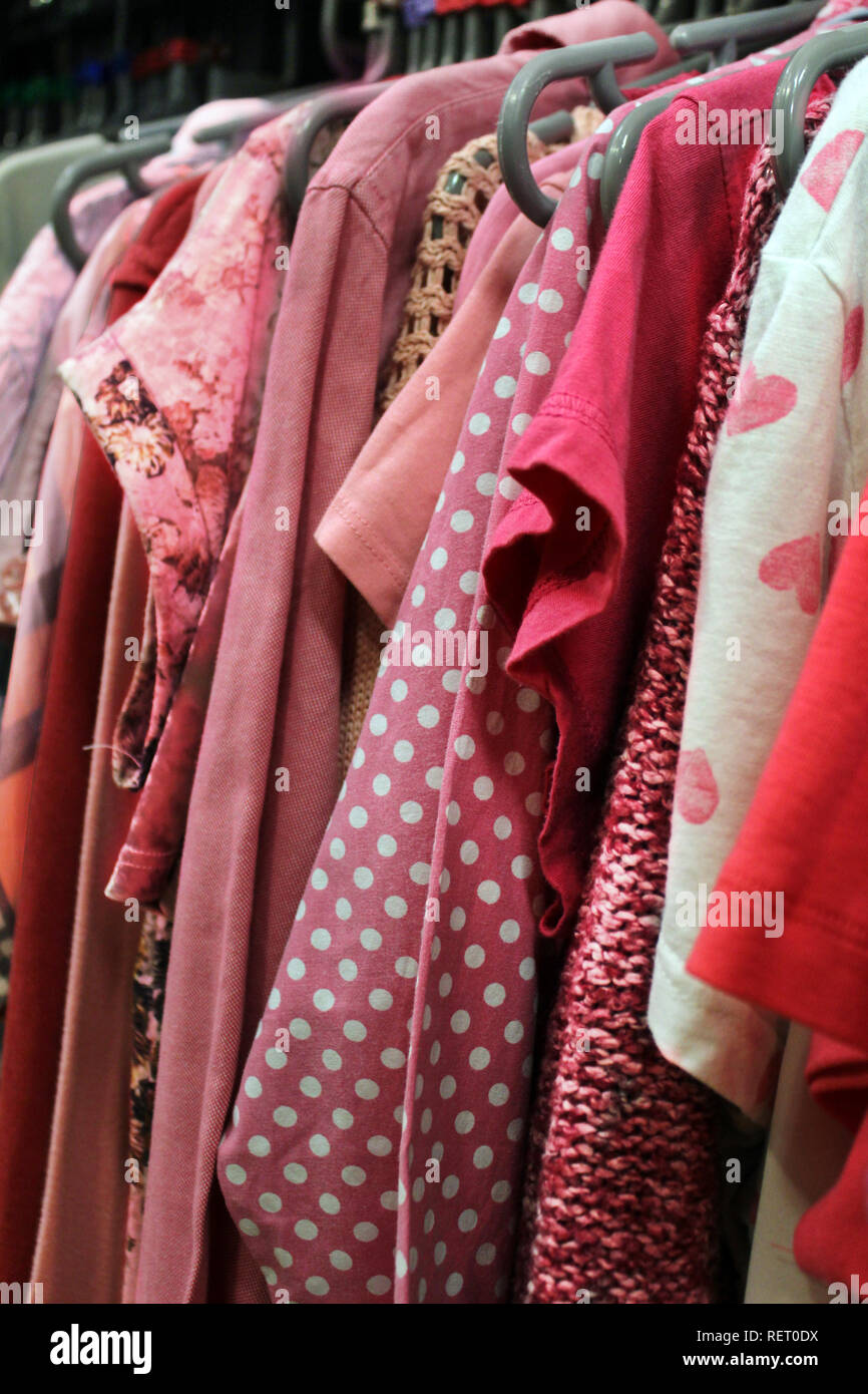 Pink women clothing hanging in vintage shop, England Stock Photo