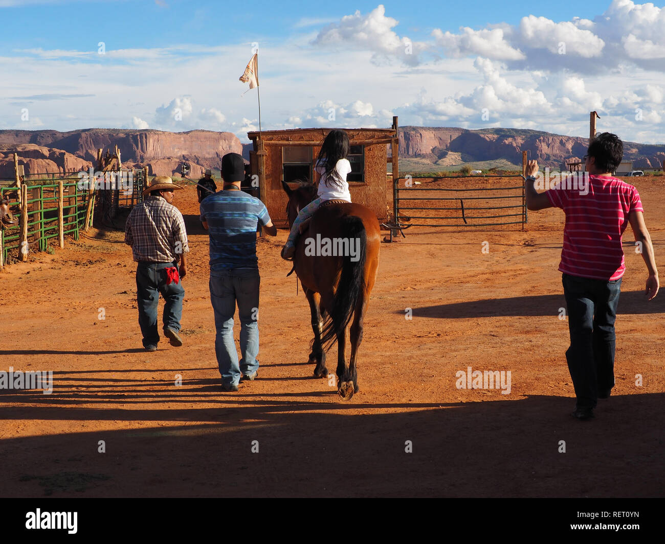 3 year old kid riding horse at monument valley hires stock photography