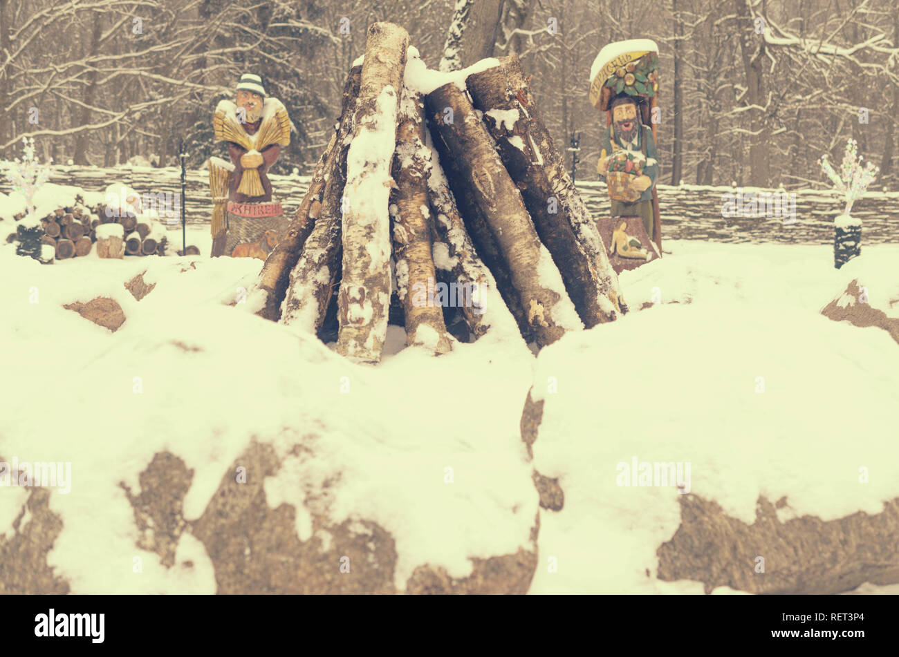 Brest, Belarus - January 11, 2019: The logs for the fire are lined with stones as temples against the statues of ancient deities Stock Photo