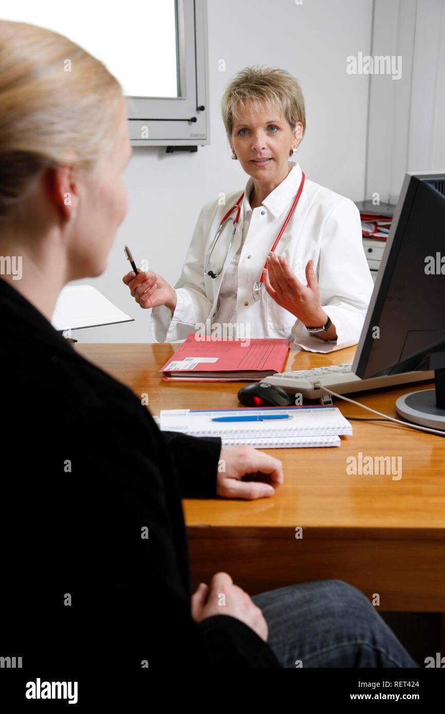 A female doctor talking to patient in hospital doctor's office Stock ...
